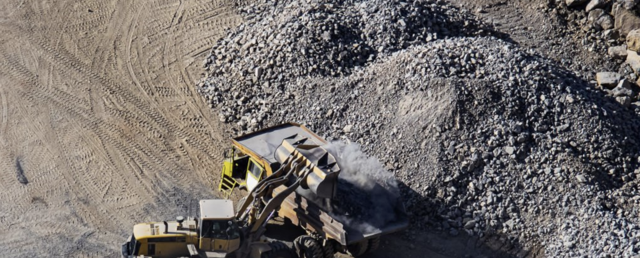 Aerial view of loader dumping material into a hauler